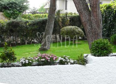 Paisajismo con jardineras escultóricas, arbolado consolidado y composición floral